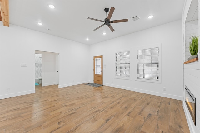 unfurnished living room with beamed ceiling, light wood-type flooring, and ceiling fan