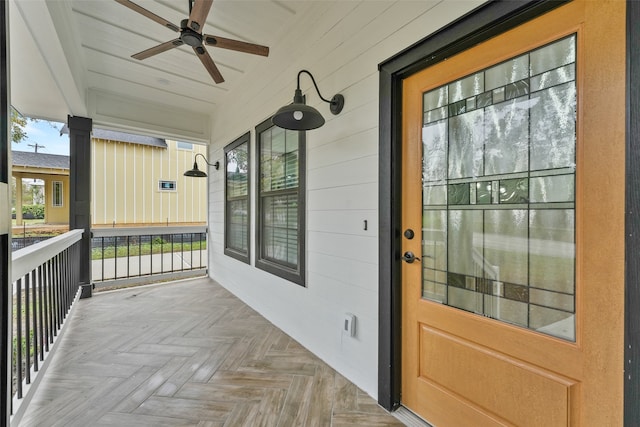 view of exterior entry featuring covered porch and ceiling fan