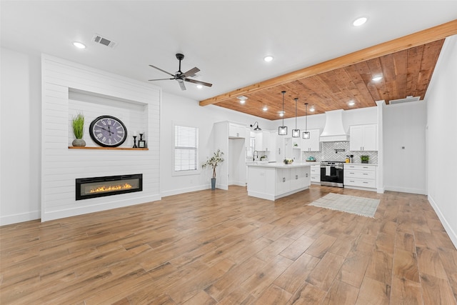 unfurnished living room with a large fireplace, ceiling fan, sink, wooden ceiling, and light hardwood / wood-style floors