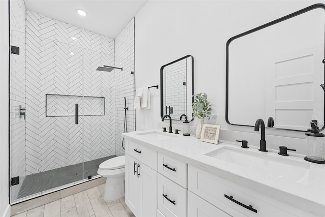 bathroom featuring hardwood / wood-style floors, vanity, toilet, and a shower with door