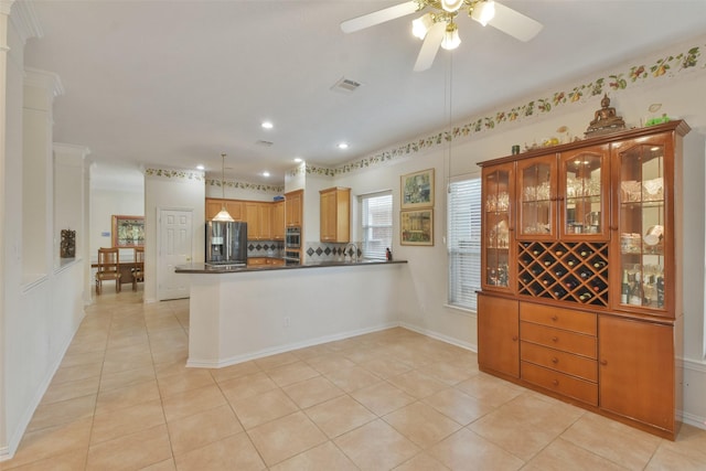 kitchen with stainless steel fridge, decorative light fixtures, kitchen peninsula, and light tile patterned floors