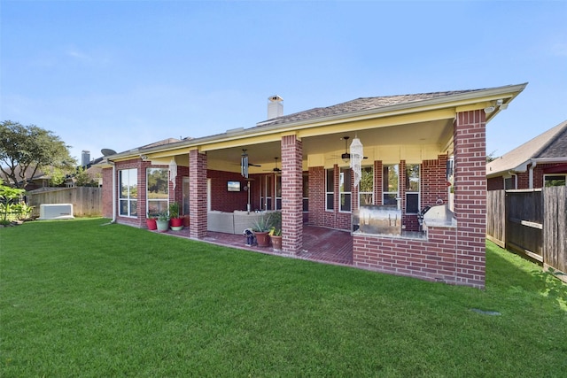 back of house with a yard and a patio