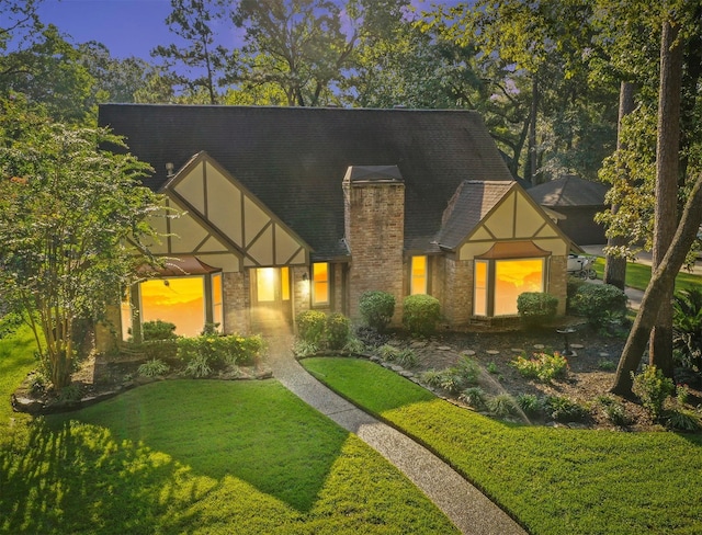 tudor-style house featuring a lawn