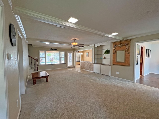 unfurnished living room featuring light colored carpet, ceiling fan, and crown molding