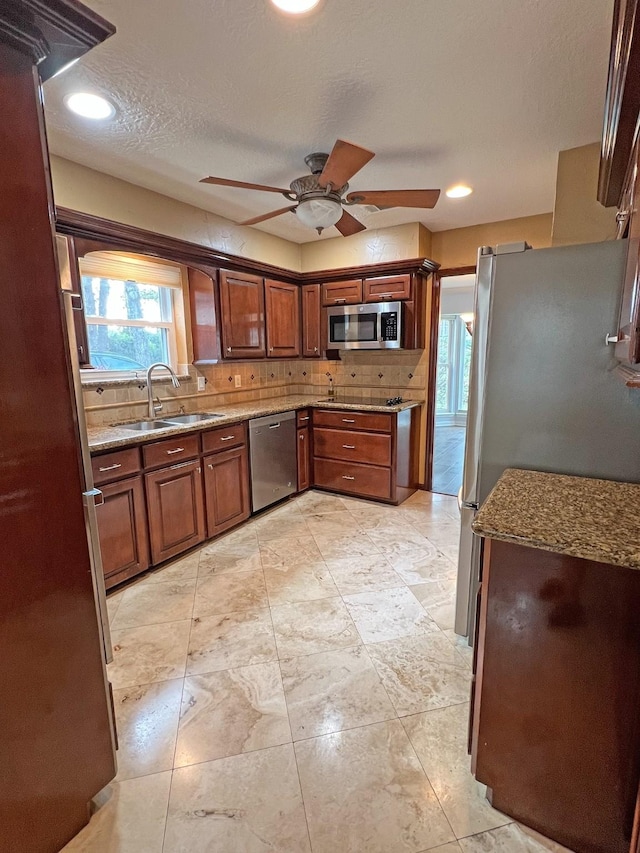 kitchen featuring decorative backsplash, sink, ceiling fan, and stainless steel appliances