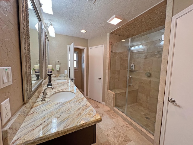 bathroom featuring vanity, an enclosed shower, and a textured ceiling