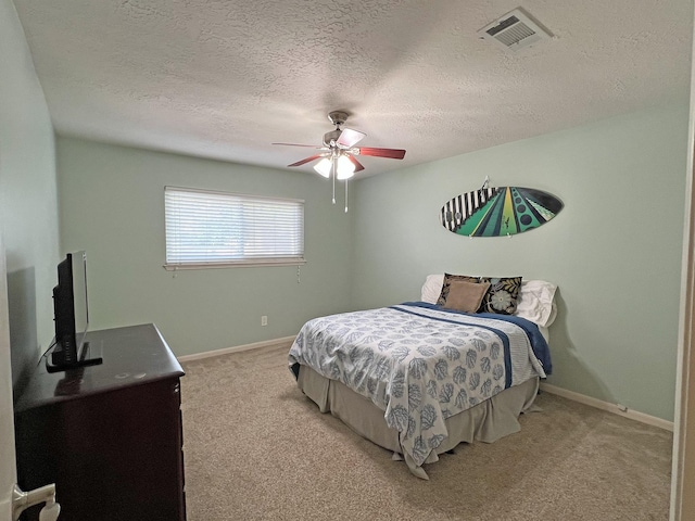 carpeted bedroom featuring ceiling fan and a textured ceiling