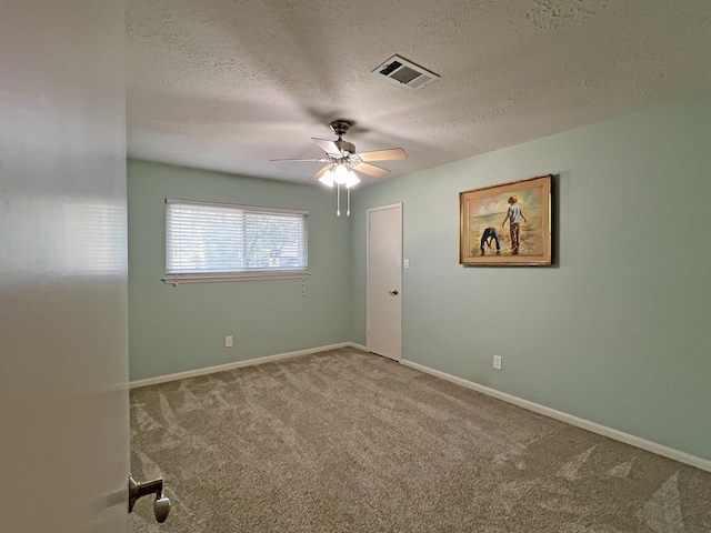 spare room with ceiling fan, carpet, and a textured ceiling