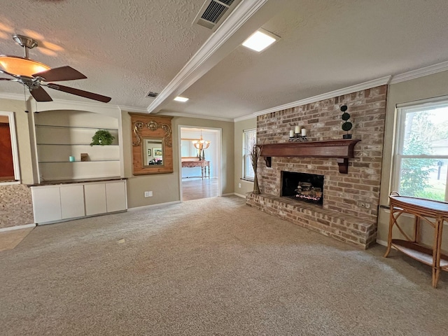 unfurnished living room featuring carpet flooring, a brick fireplace, ornamental molding, a textured ceiling, and ceiling fan with notable chandelier