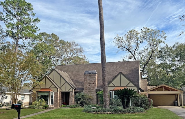 tudor house featuring a garage and a front lawn