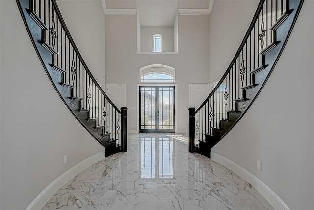 foyer featuring crown molding, french doors, and a high ceiling