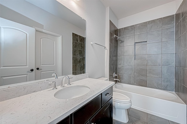 full bathroom featuring toilet, tiled shower / bath, tile patterned flooring, and vanity