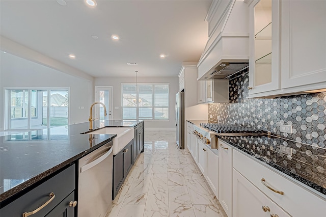 kitchen with stainless steel appliances, dark stone countertops, and white cabinets