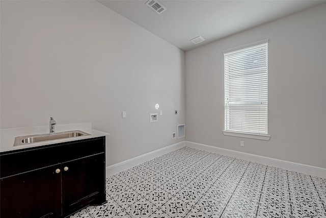 laundry room with electric dryer hookup, light tile patterned flooring, washer hookup, cabinets, and sink