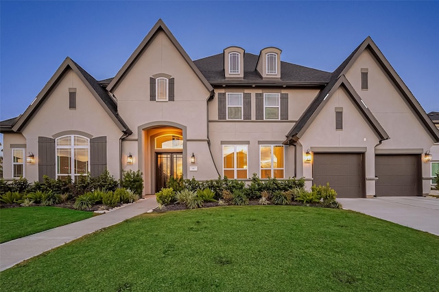 french country style house with a garage and a front lawn