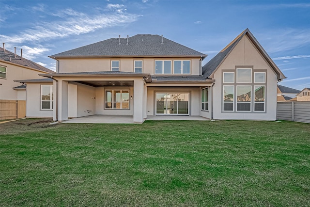 back of property with a yard and a patio