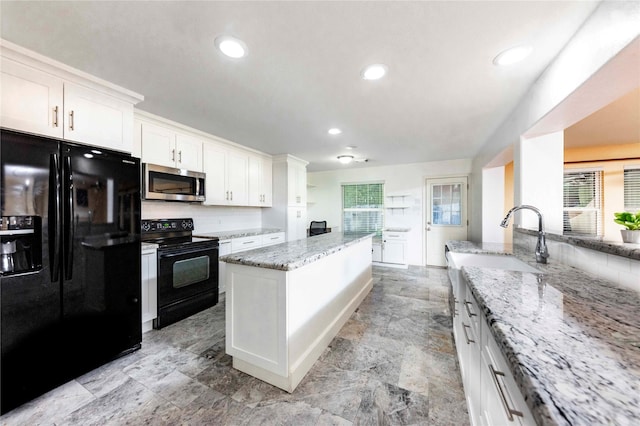 kitchen with black appliances, a kitchen island, white cabinetry, tasteful backsplash, and light stone counters