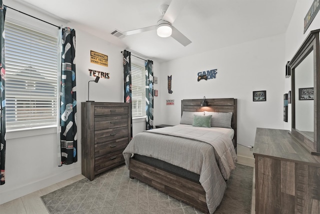 bedroom featuring multiple windows, light hardwood / wood-style flooring, and ceiling fan