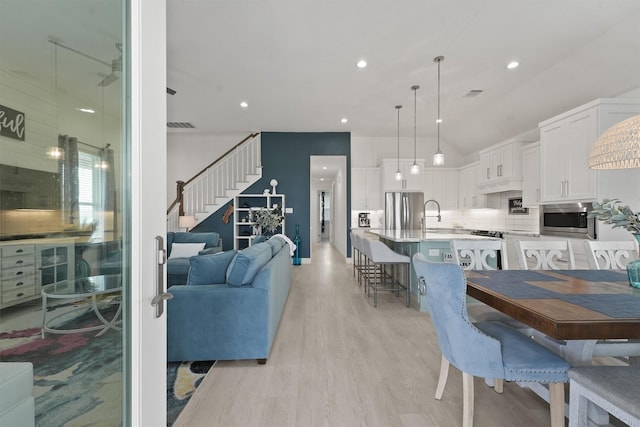 dining space with sink and light hardwood / wood-style flooring