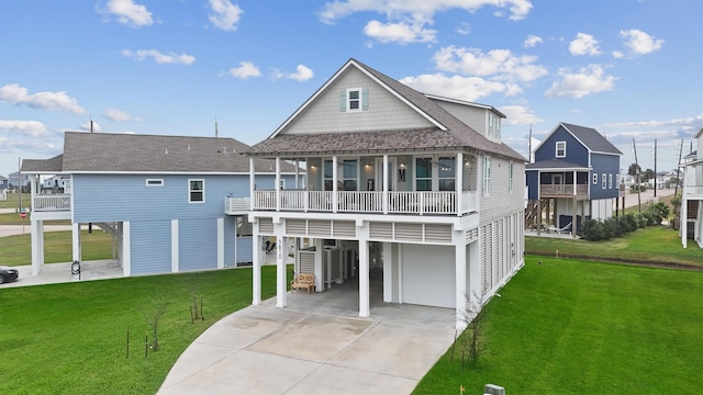 rear view of house with a carport, covered porch, a balcony, a yard, and a garage