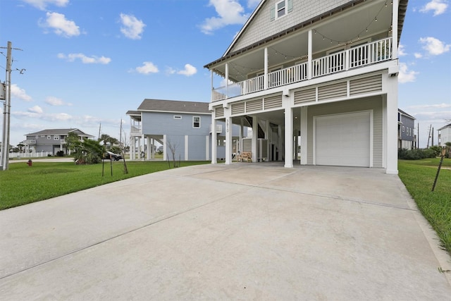 view of front of home featuring a balcony, a garage, a front yard, and a carport