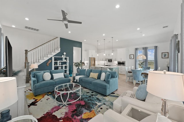 living room featuring ceiling fan, light hardwood / wood-style floors, and sink