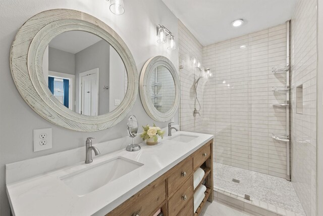 bathroom featuring tiled shower and vanity