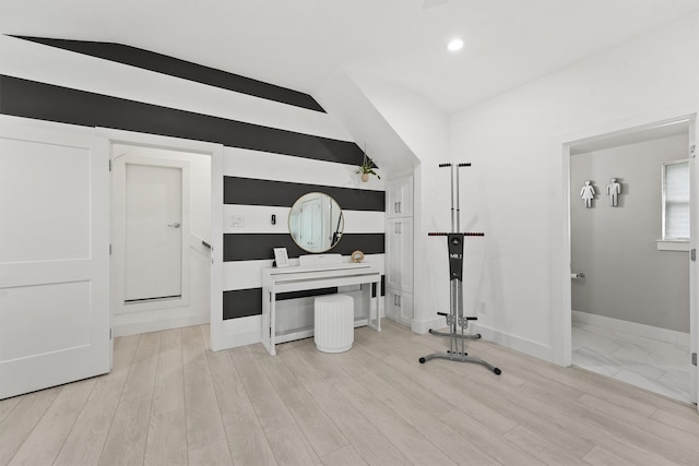 office with light wood-type flooring and vaulted ceiling