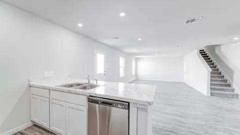 355 E Northpointe Ave, La Grange, TX 78945 - kitchen featuring stainless steel dishwasher, a sink, a peninsula, open floor plan, and white cabinetry