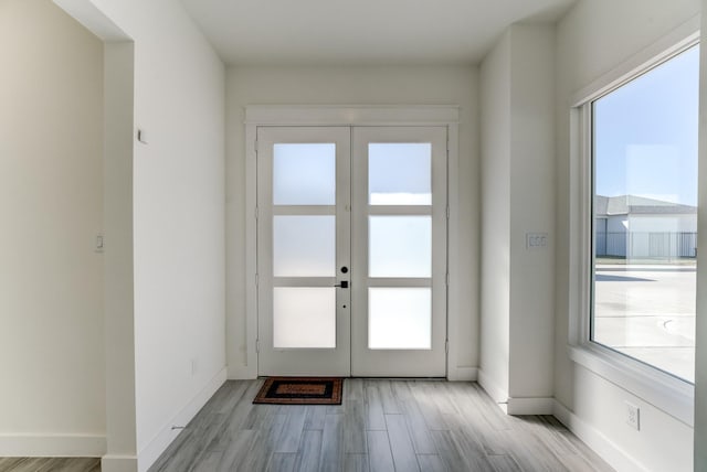 entryway featuring french doors, a healthy amount of sunlight, and light hardwood / wood-style flooring