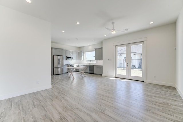 unfurnished living room featuring french doors, light hardwood / wood-style flooring, and ceiling fan