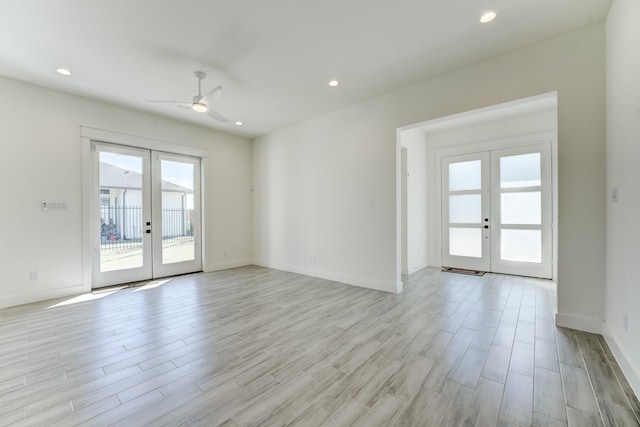 spare room with ceiling fan, light hardwood / wood-style flooring, and french doors