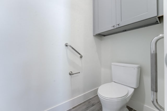 bathroom with hardwood / wood-style flooring and toilet