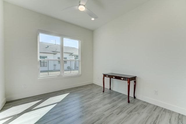 empty room with ceiling fan and light hardwood / wood-style floors