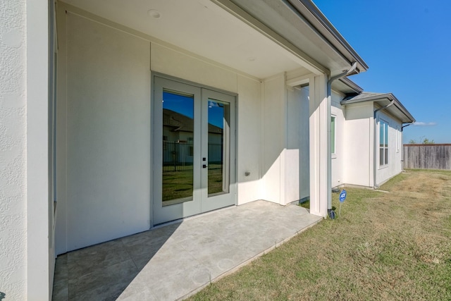 entrance to property with a lawn and a patio