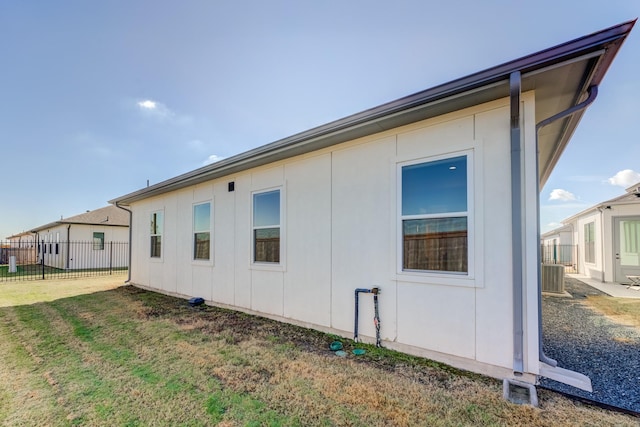 view of side of home with a yard and central AC unit