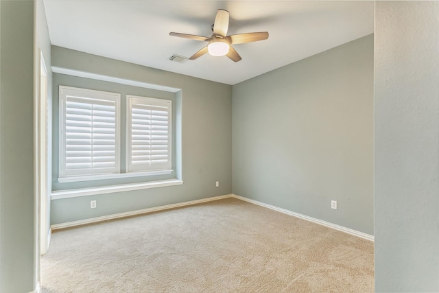 empty room featuring ceiling fan and light colored carpet