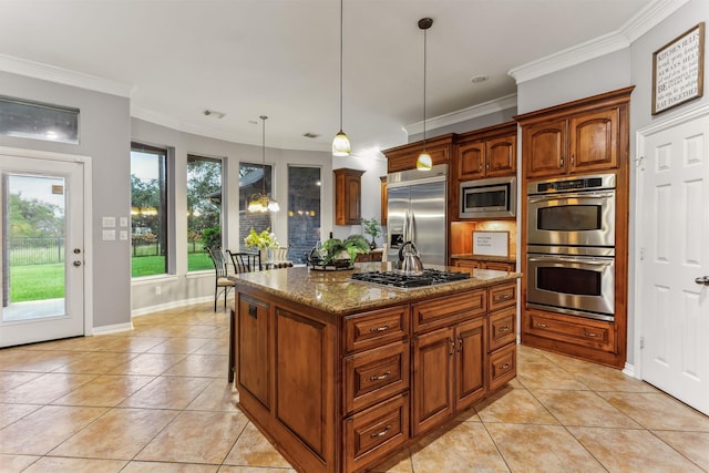 kitchen featuring crown molding, light tile patterned floors, built in appliances, a center island, and hanging light fixtures