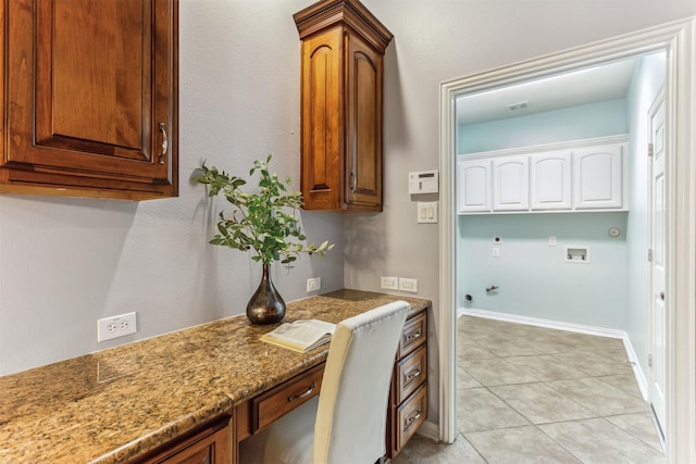 interior space featuring cabinets, washer hookup, hookup for an electric dryer, hookup for a gas dryer, and light tile patterned floors