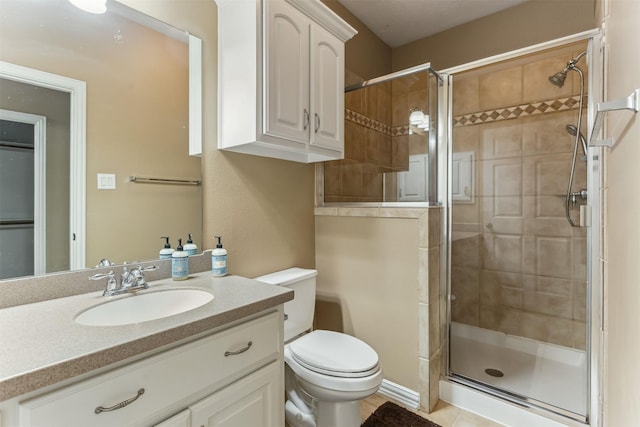 bathroom featuring tile patterned flooring, vanity, an enclosed shower, and toilet