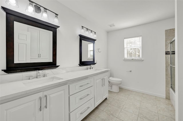 full bathroom with tile patterned flooring, vanity, combined bath / shower with glass door, and toilet