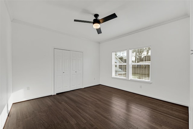 unfurnished bedroom with ceiling fan, a closet, dark wood-type flooring, and ornamental molding