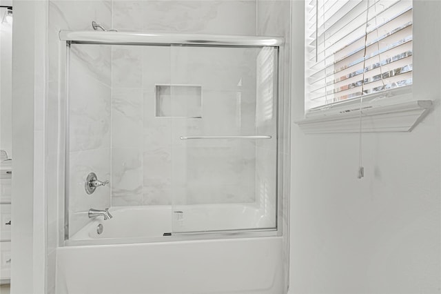 bathroom featuring bath / shower combo with glass door