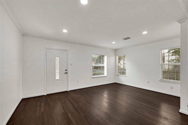 foyer with a wealth of natural light, crown molding, and dark hardwood / wood-style floors