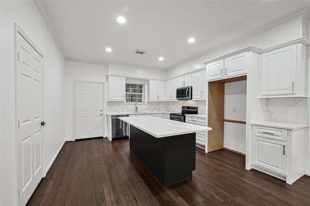 kitchen with backsplash, white cabinets, dark hardwood / wood-style floors, a kitchen island, and stainless steel appliances