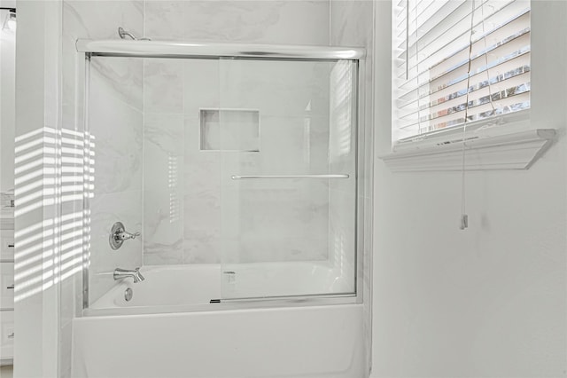 bathroom featuring bath / shower combo with glass door