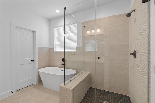 bathroom featuring tile patterned floors, separate shower and tub, and tile walls