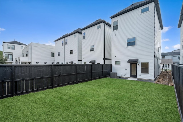 back of house featuring cooling unit and a yard