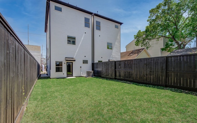 back of property featuring cooling unit and a lawn