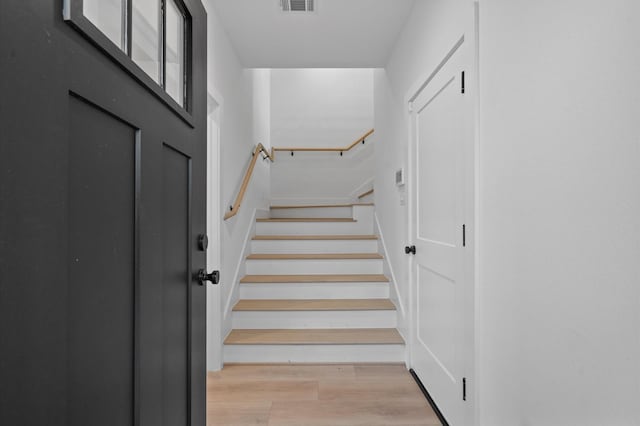 staircase with hardwood / wood-style floors